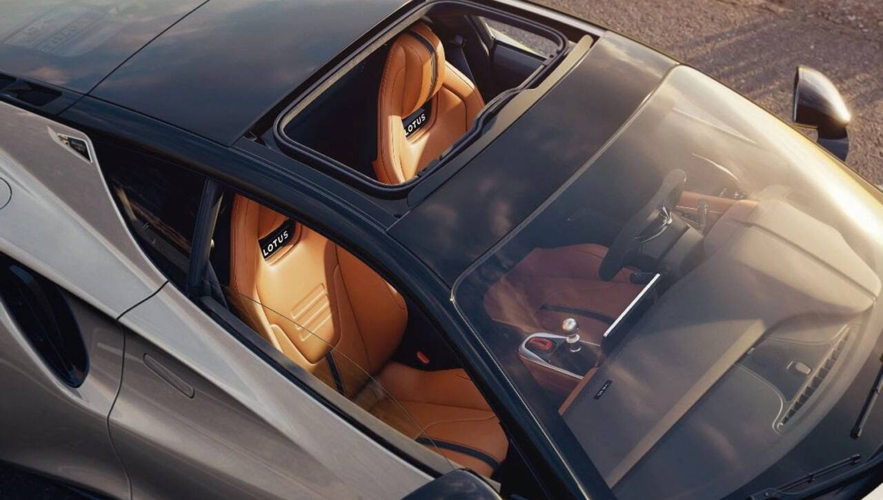 Lotus rende la Emira ancora più cattiva, ma senza tradire la sua idea di sportiva pura. La nuova Lotus Emira 420 Sport nasce per chi cerca un’auto capace di regalare sensazioni forti, non solo numeri da scheda tecnica.
Ecco la nuova Lotus Emira 420 Sport
Il motore è il quattro cilindri turbo da 2,0 litri, portato a 420 CV e 500 Nm di coppia. A gestire tutto c’è un cambio a doppia frizione a otto rapporti, rapido nelle cambiate e pensato per seguire il ritmo del guidatore. Le prestazioni sono di alto livello: la Emira 420 Sport accelera da 0 a 100 km/h in 3,9 secondi e può arrivare vicino ai 300 km/h.
Ma il punto vero, per Lotus, resta sempre lo stesso: togliere peso, migliorare il controllo e rendere la guida più comunicativa. Con il pacchetto opzionale Lightweight Handling Pack, la Emira 420 Sport risparmia 25 kg rispetto alla Emira Turbo standard e aggiunge 25 kg di carico aerodinamico. Il pacchetto include ammortizzatori Multimatic regolabili, scarico in titanio, batteria più leggera, componenti in fibra di carbonio e l’app Lotus Track Performance per analizzare le sessioni in pista.
Anche la carrozzeria lavora di più. Il nuovo splitter anteriore, le prese d’aria maggiorate, lo spoiler a labbro e il portellone posteriore con feritoie aiutano a gestire meglio i flussi d’aria. Non sono dettagli decorativi: servono a raffreddare meglio radiatori e freni, mantenendo le prestazioni più costanti quando il ritmo sale. Lotus dichiara un flusso d’aria verso i radiatori aumentato fino al 15% e un’efficienza dei freni migliorata del 10%.
La novità più affascinante è il tetto in vetro oscurato rimovibile, disponibile su tutta la gamma Emira. Una soluzione che permette di godersi la guida a cielo aperto, rendendo l’esperienza ancora più coinvolgente